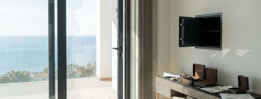 Smashed glass door and empty safe after a burglary in a luxury Costa del Sol apartment, highlighting the need for private contents insurance.