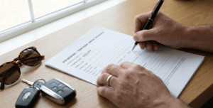 Signing temporary car insurance documents for foreign plates in Spain.