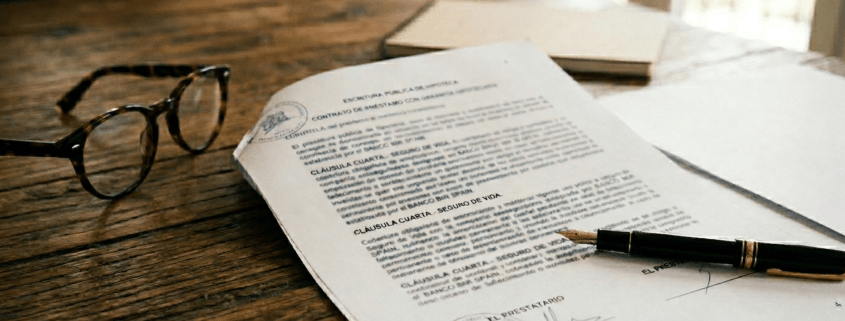 Spanish mortgage contract with life insurance clauses on a desk.
