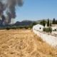 Dry vegetation near a white Spanish country house highlighting wildfire risk.