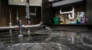 Tubería de agua rota inundando el suelo de mármol de un apartamento en Mijas.