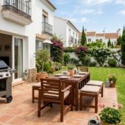 Modern gas barbecue and wooden patio furniture in a Spanish garden