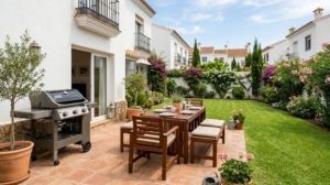 Modern gas barbecue and wooden patio furniture in a Spanish garden