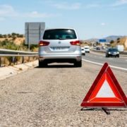 Triángulo de emergencia detrás de un coche familiar averiado en España.